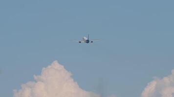 Long shot of jet plane climbing in blue cloudy sky. The airplane flying near cumulus clouds video