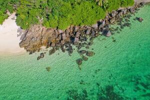 Drone aerial shot of Anse royale, fairy land of beautiful white sandy beach with granite stones and lush greenery, Mahe Seychelles photo