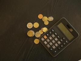Coin and calculator on wooden table, saving money for the future and life. photo