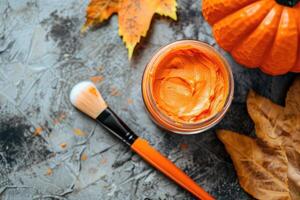 Pumpkin face mask top view, with pumpkin, brush and fall leaves. Copy space. photo