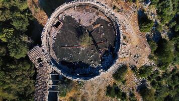 Drone capturing an abandoned ancient tower with a missing roof in the forest photo