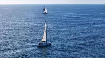 Sailboats gliding gracefully across a tranquil blue sea under a clear sky during a serene afternoon photo