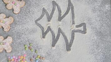 a child's hand draws a Christmas tree in flour photo