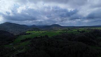Vast green valleys and rolling hills under a dramatic cloudy sky during late afternoon in a serene countryside landscape photo