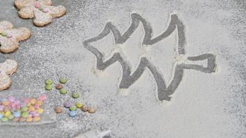 a child's hand draws a Christmas tree in flour photo
