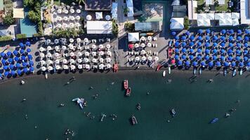 A vibrant summer day at the beach with colorful umbrellas and lively activities on the water in a popular coastal resort photo