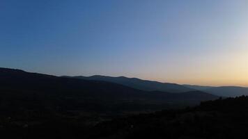 A tranquil twilight over rolling hills creates a serene landscape in the fading light of sunset photo