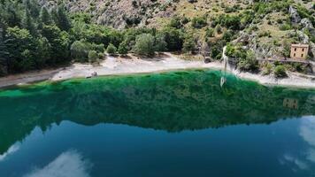 Tranquil waters reflecting lush greenery at a serene lakeside in the heart of nature under a clear blue sky photo