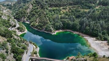 Serenity of emerald waters reflecting lush greenery in a tranquil mountain landscape during a sunny day photo