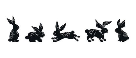 Set of rabbit silhouettes in different poses. Hand drawn rabbits decorated with white ornament with botanical elements vector