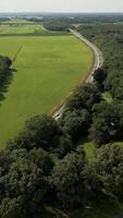 aerial view of a highway surrounded by forests and farm fields video