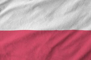 Poland flag depicted on folded wavy fabric of old cloth photo