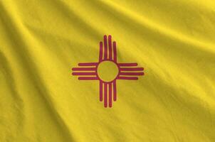 New Mexico US state flag depicted on folded wavy fabric of old cloth photo