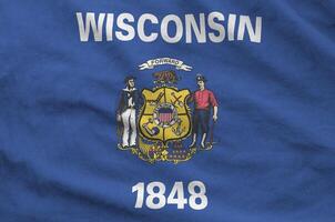 Wisconsin US state flag depicted on folded wavy fabric of old cloth photo