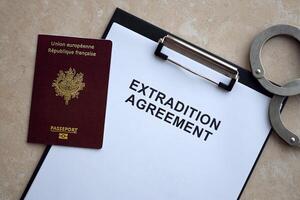 Passport of France and Extradition Agreement with handcuffs on table photo