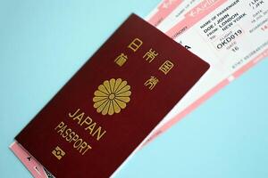 Japan passport with airline tickets on blue background close up photo
