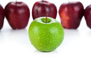maroon apples lined up in a row and green apple closeup photo