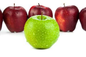 maroon apples lined up in a row and green apple closeup photo