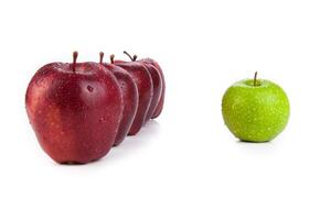 maroon apples lined up in a row and green apple closeup photo