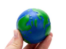 rubber ball in the form of a globe of the planet earth in the hand of man photo