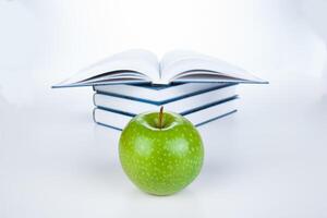 stack of books with green apple photo