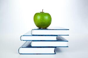 stack of books with green apple photo