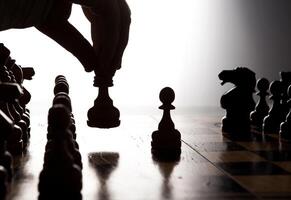 man makes a move chess figure photo