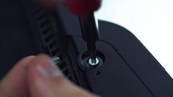 Close-up macro plastic electronic device like laptop or gaming console screwed with torx screws by repairman in the workshop video