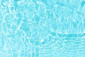 Bluewater waves on the surface ripples blurred. Defocus blurred transparent blue colored clear calm water surface texture with splash and bubbles. Water waves with shining pattern texture background. photo