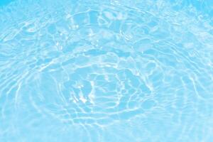 Bluewater waves on the surface ripples blurred. Defocus blurred transparent blue colored clear calm water surface texture with splash and bubbles. Water waves with shining pattern texture background. photo