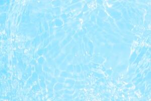 Bluewater waves on the surface ripples blurred. Defocus blurred transparent blue colored clear calm water surface texture with splash and bubbles. Water waves with shining pattern texture background. photo