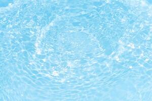 Bluewater waves on the surface ripples blurred. Defocus blurred transparent blue colored clear calm water surface texture with splash and bubbles. Water waves with shining pattern texture background. photo