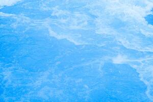 Bluewater waves on the surface ripples blurred. Defocus blurred transparent blue colored clear calm water surface texture with splash and bubbles. Water waves with shining pattern texture background. photo