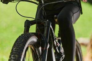 A sports bicycle races through the park, its components in focused motion spinning wheels, agile pedals, and sleek handlebars creating a dynamic spectacle of athleticism and speed against the backdrop photo