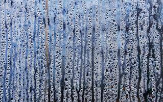 Texture of rain drops on a glass wet transparent surface. photo