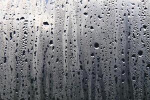 Texture of rain drops on a glass wet transparent surface. photo