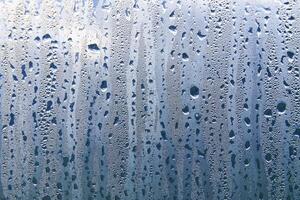 Texture of rain drops on a glass wet transparent surface. photo