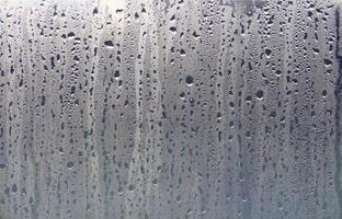 Texture of rain drops on a glass wet transparent surface. photo
