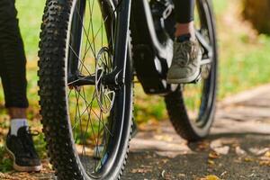 A sports bicycle races through the park, its components in focused motion spinning wheels, agile pedals, and sleek handlebars creating a dynamic spectacle of athleticism and speed against the backdrop photo