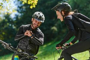 A sweet couple, equipped with bicycles and engrossed in coordinating their journey, checks their GPS mobile and watches while planning scenic routes in the park, seamlessly blending technology and photo