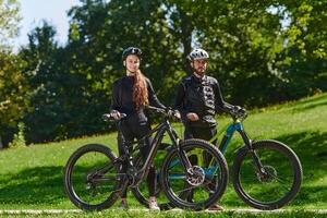 A sweet couple, equipped with bicycles and engrossed in coordinating their journey, checks their GPS mobile and watches while planning scenic routes in the park, seamlessly blending technology and photo
