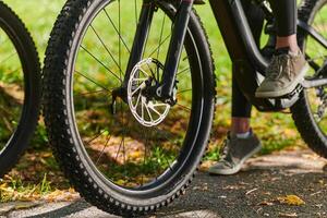 A sports bicycle races through the park, its components in focused motion spinning wheels, agile pedals, and sleek handlebars creating a dynamic spectacle of athleticism and speed against the backdrop photo