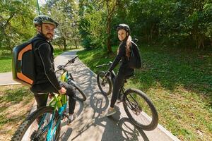A sweet couple, adorned in cycling gear, rides their bicycles, their hands interlocked in a romantic embrace, capturing the essence of love, adventure, and joy on a sunlit path photo