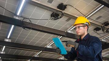 Engineer technical service checking solar panel while monitoring the system of solar panel on his tablet to make sure that's it work properly photo