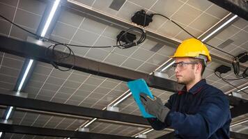 Engineer technical service checking solar panel while monitoring the system of solar panel on his tablet to make sure that's it work properly photo
