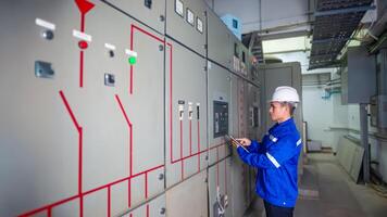 Electrical engineer check the operation of the main electrical control panel photo