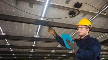 Engineer technical service checking solar panel while monitoring the system of solar panel on his tablet to make sure that's it work properly photo