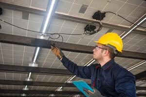 Engineer technical service checking solar panel while monitoring the system of solar panel on his tablet to make sure that's it work properly photo