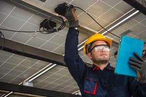 Engineer technical service checking solar panel while monitoring the system of solar panel on his tablet to make sure that's it work properly photo