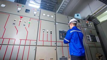Electrical engineer check the operation of the main electrical control panel photo